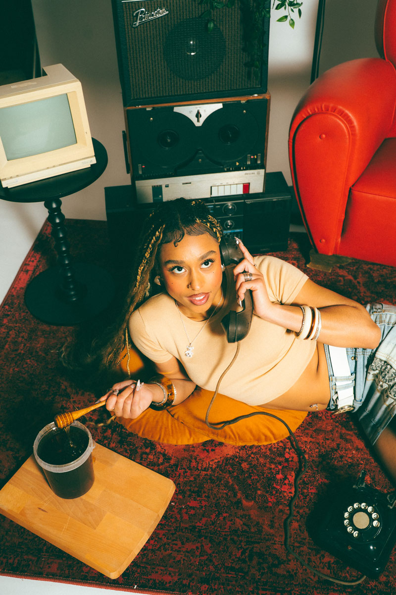 Edaya au téléphone dans un décor vintage avec pot de miel, visuel du single Sans Effort